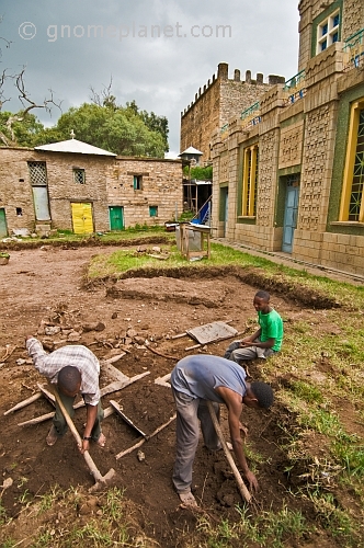 caption: Workmen clearing the ground adjacent to the 'Chapel of the Tablet'.
