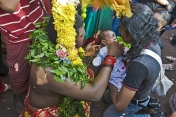 Thaipusam devotee gives holy prasad sweet to a baby