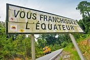An Oasis Overland truck stops to see the road sign marking the Crossing of the Equator.