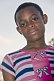 Gabonese teenager with short hair wears a striped blue white and pink dress.
