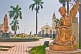 Image of Golden statues of angel and Virgin Mary in front of the white and gray Roman Catholic church.