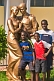 Image of Three boys in football shirts stand in front of gold painted statue of dancing couple.