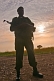 Image of An Angolan soldier with assault rifle silhouetted at dawn.
