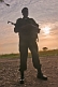 Image of An Angolan soldier with assault rifle silhouetted at dawn.