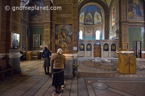 Worshippers pray before the icons in the Eastern Orthodox cathedral.