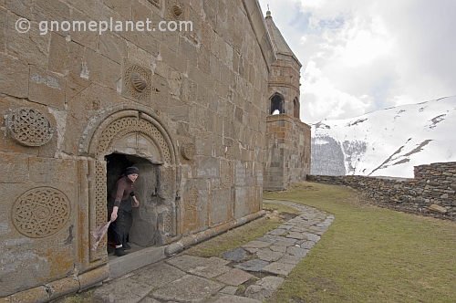 A nun shakes a cloth outside of the Tsminda Sameba Monastery, in the mountains overlooking Kazbegi.