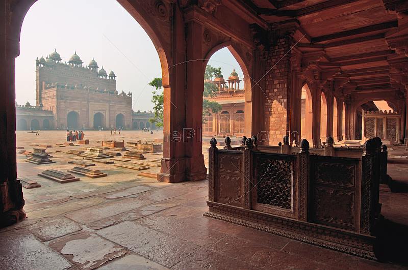 Walkway and courtyard tombs of Akbar's Jami Masjid in early morning light.