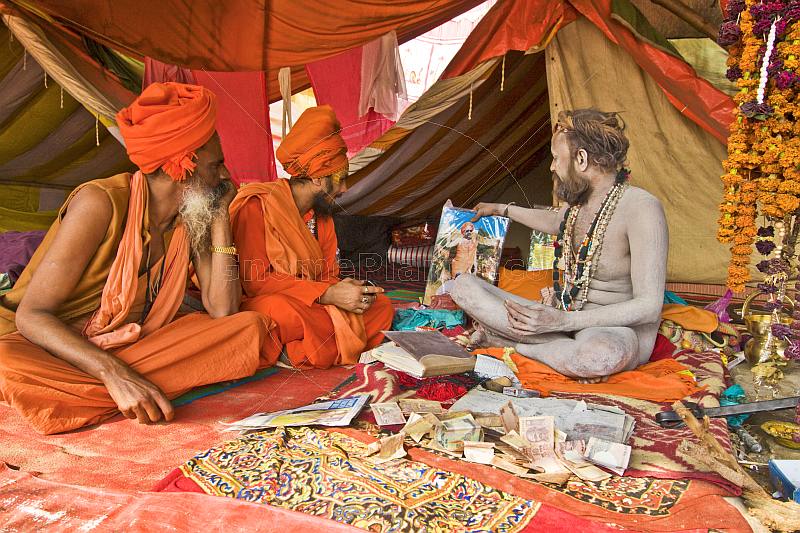 Juna Akhara Naga shows Guru picture to two Sadhus.