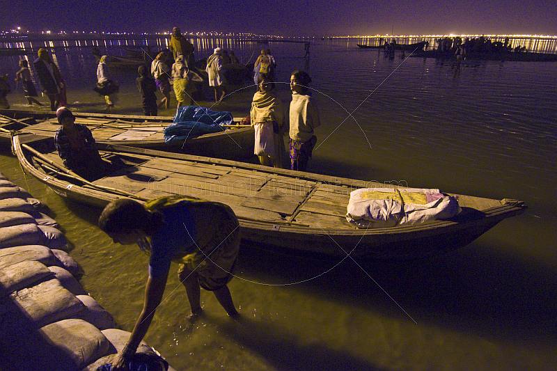 Rowing boats next to pontoon bridge 18 at Ganges Yamuna Sangam in pre-dawn light.