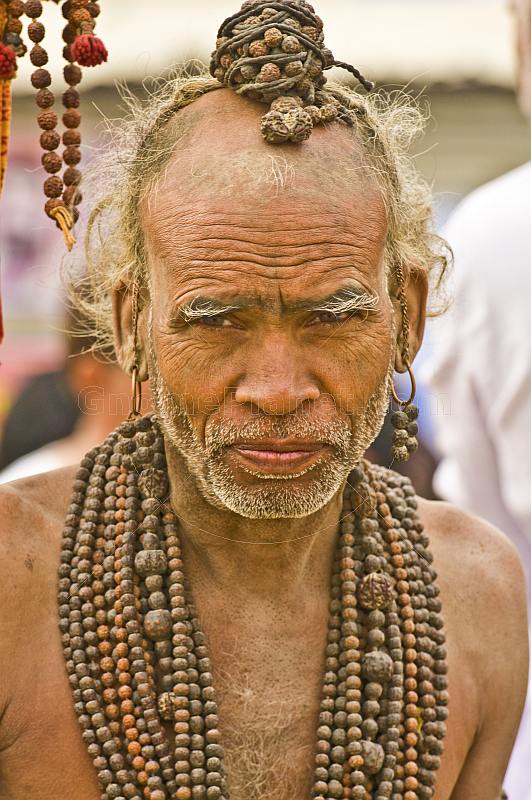 Elderly Hindu Holy Man with Rudraksha bead necklaces in Kumbh Mela procession.