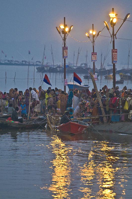 Pilgrims bathe in crowded Ganges Yamuna River Sangam area before dawn.