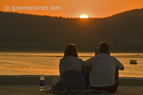 Two western tourists watch the sunset over Lake Pichola.