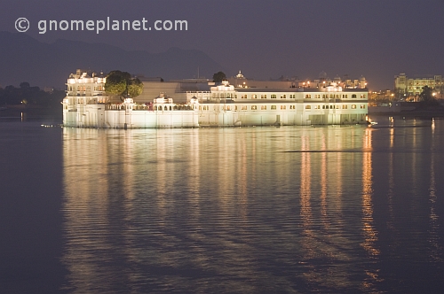 Floodlights illuminate the Lake Palace Hotel on Lake Pichola at dusk.