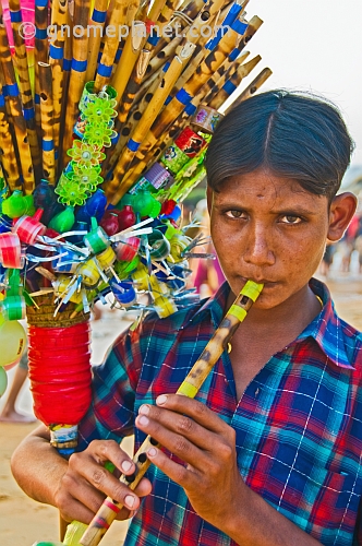 A whistle-seller demonstrates his wares on Leela Beach.