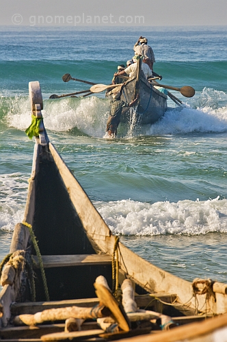 Fishermen battle the waves to launch their boat at Kovalam Beach.