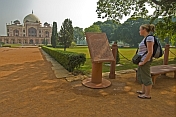 Young female Western tourist reads an account of the history of Humayun's Tomb.