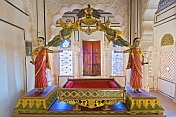 Golden throne with painted statues at the Meherangarh Fort Palace Museum.