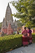 Two Tibetan lady pilgrims rest from their devotions to look at the Mahabodhi Temple.