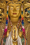 Buddhist statue in colorful robes and jewels at the Bhutanese Temple.