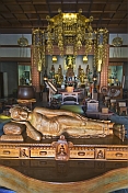 Wooden reclining Buddha statue in front of the altar of the Japanese Temple in Sarnath.