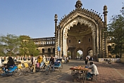 Cycle rickshaws drive through the elaborate gateway of the Rumi Darwaza.