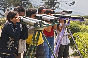 Indian tourists view the mountains through home made binoculars at the Batasia Loop.