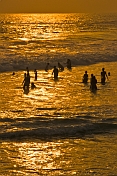Bathers in the Arabian Sea at sunset.