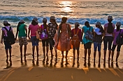 Indian schoolgirls and their teacher line up at the shore to watch the sunset.
