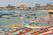 Boats at anchor in Vizhinjam fishing harbour, with mosque in the distance.