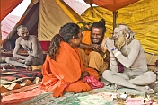 Juna Akhara Nagas share a joke at their Maha Kumbh Mela camp.