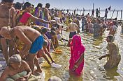 Mass crowds of Hindu pilgrims struggle to bathe in shallows of Ganges river Sangam.