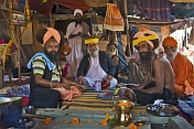 Group of Holy Men in turbans pose for photograph at Kumbh Mela festival encampment.