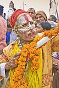 Hindu holy man with whitened face and nose ring poses for the camera.