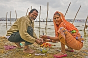 Hindu pilgrim married couple perform private ceremony next to Ganges river Sangam.