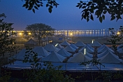 Lines of canvas police tents in pre-dawn light next to Ganges river Sangam.