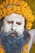 Juna Akhara Naga with Vibhuti sacred ash covered face and marigold flower garlands.