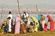 Pilgrims on east bank of Ganges watch the mass crowds bathing on the west bank.