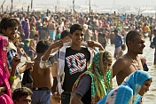 Young man with Dolce and Gabana teeshirt at crowded Ganges Sangam bathing ghats.