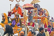 Holy Men wait patiently on vehicle roofs for Hindu procession traffic jam to clear.