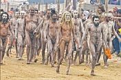 Ash-smeared Naga Holy Men walk in procession from Ganges river bathing ceremony.