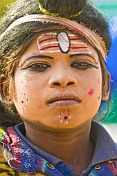Boy with Hindu God face paint raises money from Kumbh Mela pilgrim visitors.