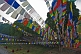 Image of Buddhist monks rest under the shade of trees and prayer-flags.