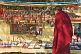 A Tibetan monk looks at Buddhist religious trinkets for sale.