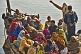 Image of Pilgrims crowd on to a boat to cross the Ganges River.