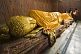 Image of Pilgrims place scarves on the 6m recumbent statue of the dying Buddha in the Parinivarna Temple.