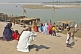 Image of An old man watches pilgrims go for a ritual dip at the bathing ghats on the Saryu River.
