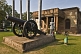 Image of A siege cannon with statue of a period-costumer gunner stand outside the Residency building, now a museum to the Indian Mutiny of 1857.