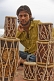 A young Indian man selling drums.