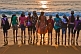 Indian schoolgirls and their teacher line up at the shore to watch the sunset.