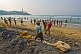 Image of Fishermen haul their fishing net on to the beach.